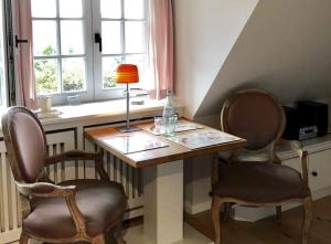 a room with a table with two chairs and a lamp at Apartmenthaus Witthüs in Wenningstedt