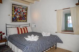 a bedroom with a bed with two lilies on it at PATMOS Mathios Studios- apartments in Patmos