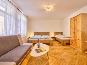 Cette chambre comprend deux lits, un canapé et une table. dans l'établissement Studio Villa Belvedere-8 by Interhome, à Janské Lázně
