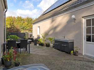 a patio with a sink and a table and chairs at Holiday Home Amma - 21km from the sea in Western Jutland by Interhome in Bredebro