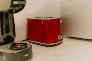 a red toaster sitting on a counter next to a blender at Gemütliches Haus mit 2 Zimmern in Vallendar
