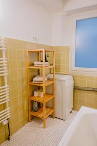 une salle de bains avec une étagère, des serviettes et un lave-linge. dans l'établissement Gemütliches Haus mit 2 Zimmern, à Vallendar
