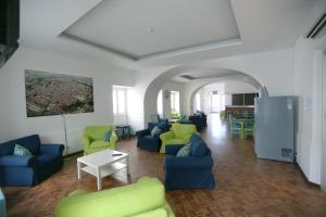 a living room with blue and green chairs and a table at HI Évora – Pousada de Juventude in Évora