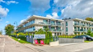 a building with two red chairs in front of it at Rezydencja Niechorze 225 - 5D Apartamenty in Niechorze