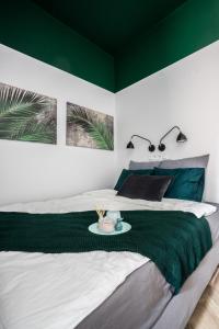 a bedroom with a bed with a green accent wall at GA- Cozy Studio - Praga&Ząbkowska in Warsaw