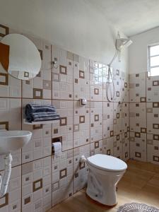 y baño con aseo y lavamanos. en Pousada Rota da Serra, en Munhoz