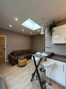 a living room with a couch and a table at Modern Garden Studio for comfy stay in Luton