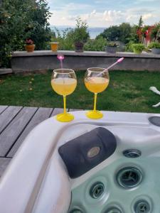 due bicchieri da vino seduti sopra una vasca da bagno di Le Chalet des 3 Ours a Neuvecelle