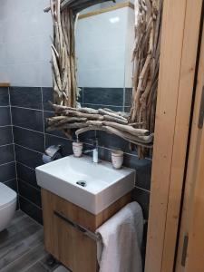 a bathroom with a sink and a mirror at Le Chalet des 3 Ours in Neuvecelle