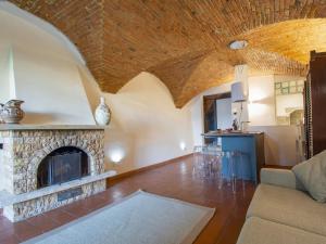 uma sala de estar com uma lareira de pedra e uma mesa em Apartment Il Giardino di Lucia by Interhome em San Miniato