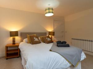 two beds in a room with two lamps and two beds sidx sidx sidx at Holiday Home 1 Railway Cottage by Interhome in Aviemore