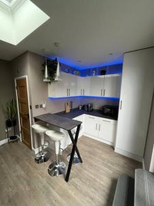 a kitchen with a table and some blue ceilings at Modern Garden Studio for comfy stay in Luton