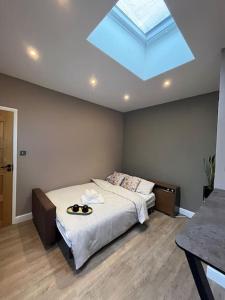 a bedroom with a large bed with a skylight at Modern Garden Studio for comfy stay in Luton