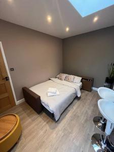 a bedroom with a bed and a sink in it at Modern Garden Studio for comfy stay in Luton
