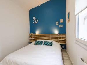 Un dormitorio con una cama con una pared azul. en Holiday Home Les Trémières by Interhome, en La Palmyre