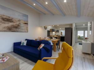 Una sala de estar con un sofá azul y sillas amarillas. en Holiday Home Les Trémières by Interhome, en La Palmyre 22 fotos más