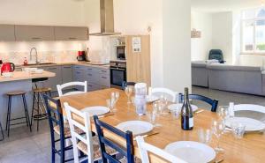 a dining room with a table and chairs and a kitchen at Gîte du Pavement in Craon