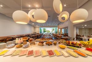 a buffet line with food on display in a cafeteria at Lifestyle Laghetto Collection in Rio de Janeiro