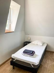 1 dormitorio con 1 cama con sábanas blancas y ventana en Gîte du Pavement, en Craon