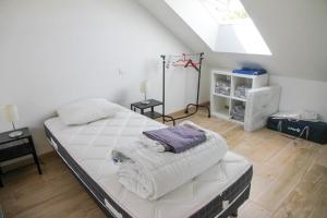 1 dormitorio con 1 cama grande y toallas. en Gîte du Pavement, en Craon