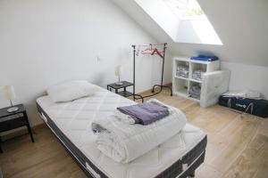 a bedroom with a large bed with towels on it at Gîte du Pavement in Craon