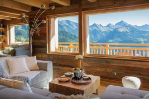 a living room with couches and a view of mountains at Chalet Serbijanka - OVO Network in Manigod
