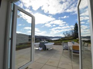 a sliding glass door with a view of a patio at Holiday Home Achalic Farm House by Interhome in Lerags
