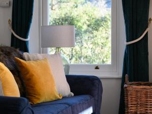 a living room with a blue couch and a window at Holiday Home Achalic Farm House by Interhome in Lerags