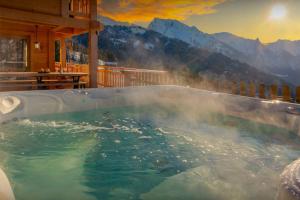 a jacuzzi tub with a view of the mountains at Chalet Serbijanka - OVO Network in Manigod