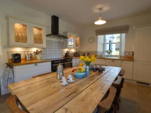 a kitchen with a wooden table with a bowl of fruit on it at Holiday Home Achalic Farm House by Interhome in Lerags +40 photos