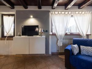 salon z telewizorem i niebieską kanapą w obiekcie Holiday Home Da Norma by Interhome w mieście San Martino di Terzo