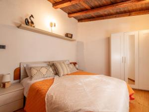 una camera con un letto bianco e una coperta arancione di Holiday Home Da Norma by Interhome a San Martino di Terzo