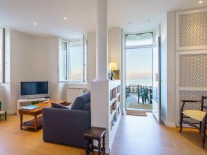 a living room with a couch and a television at Apartment Villa La Concha-1 by Interhome in Saint-Jean-de-Luz