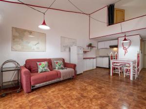 a living room with a red couch and a kitchen at Apartment I-1-4 by Interhome in Golfo Aranci
