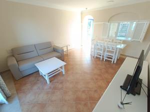 イスラ・カネラにあるURBANIZACIÓN SAN BRUNO II 2 DORM EN 1º PLANTAのソファとテーブルのあるリビングルーム