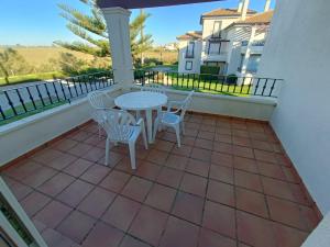 イスラ・カネラにあるURBANIZACIÓN SAN BRUNO II 2 DORM EN 1º PLANTAのバルコニーにテーブルと椅子が置かれたパティオ