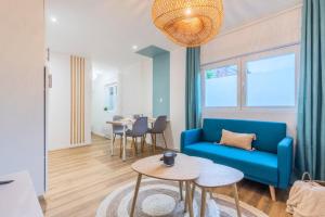 a living room with a blue couch and tables at 1 bedroom apartment near tram, CHR + parking in Roubaix