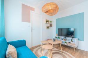 a living room with a blue couch and a table at 1 bedroom apartment near tram, CHR + parking in Roubaix