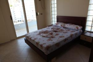 ein Schlafzimmer mit einem Bett mit einem Teller darauf in der Unterkunft Bakija Apartments in Sarandë