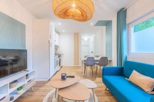 a living room with a blue couch and a table at 1 bedroom apartment near tram, CHR + parking in Roubaix +12 photos