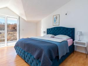 Holiday Home Secret Gem by Interhome في Donji Proložac: سرير أزرق في غرفة نوم بيضاء مع نافذة