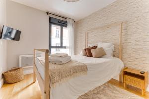 a white bedroom with a large bed and a window at Palais des congrès , 4 bedrooms in Levallois-Perret