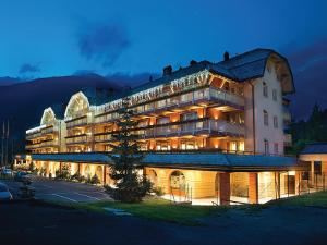 a large building with a lot of lights on at Residence Club Ponte Di Legno in Ponte di Legno