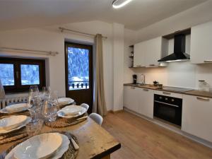 a kitchen and dining room with a table and chairs at Apartment Guanella Apartment by Interhome in Campodolcino