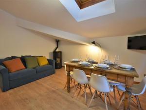a living room with a table with chairs and a couch at Apartment Guanella Apartment by Interhome in Campodolcino