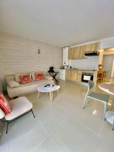 a living room with a couch and tables and a kitchen at 3 pièces- Vieux port- Terrasse - Parking Possible in Cannes