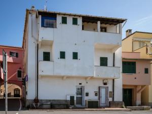 ein weißes Gebäude mit grünen Fenstern auf einer Straße in der Unterkunft Apartment Alice 3 by Interhome in Riva Ligure