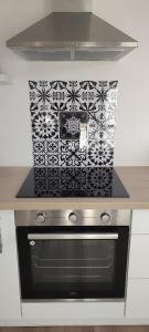 een oven met een zwarte en witte kookplaat bij Le Cocooning in Aureilhan