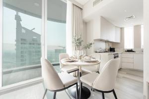 a kitchen and dining room with a table and chairs at Stayis - 1 BR Marina suite in Dubai