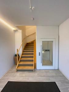 eine Treppe in einem Zimmer mit einer Tür und einem Teppich in der Unterkunft AS Ferienzentrum in Butjadingen